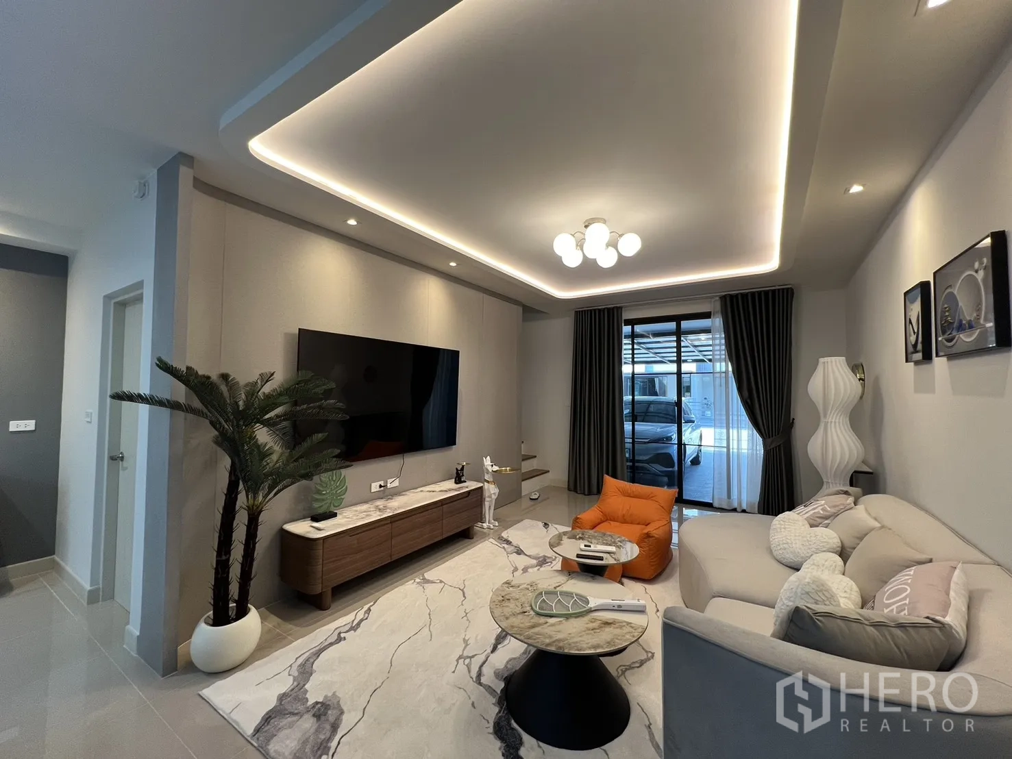 Townhouse for rent in Bang Phli, Samut Prakan - Lounge facing sliding doors and carport, complete with drapes and feature lighting.