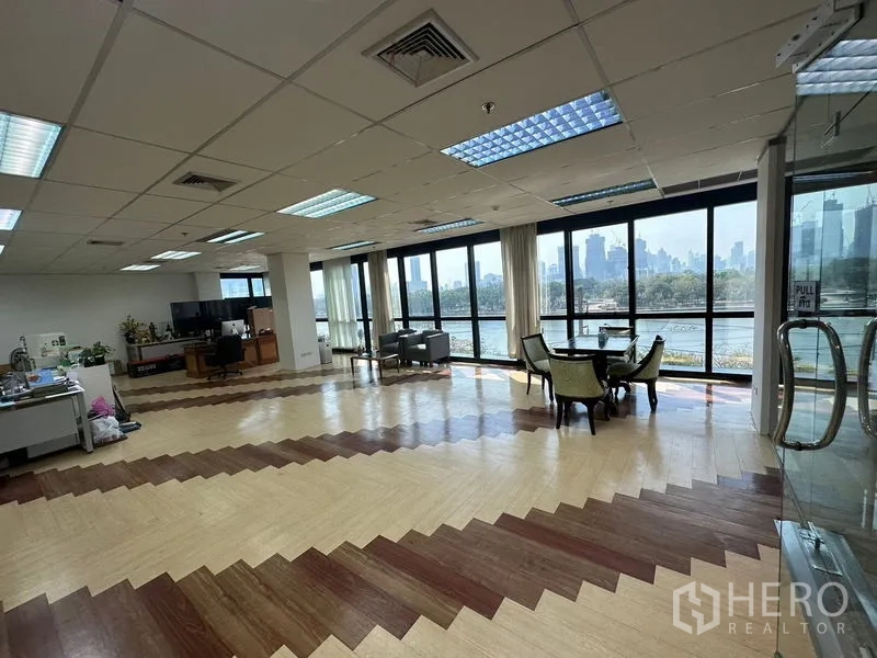 Office Space for rent in Khlong Toei, Bangkok - Spacious open-plan office with floor-to-ceiling windows overlooking Benjakitti Park lake and Bangkok skyline, with a meeting set by the glass.
