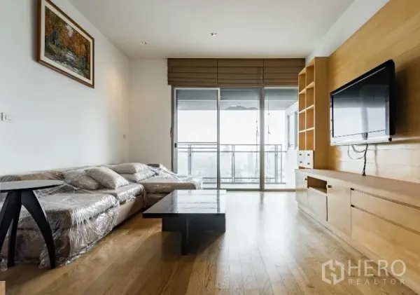 คอนโด ให้เช่าในWatthana, Bangkok - ห้องนั่งเล่นสว่าง โซฟาเข้ามุม ประตูกระจกบานเลื่อนเปิดสู่ระเบียง และตู้บิลท์อินสำหรับทีวี