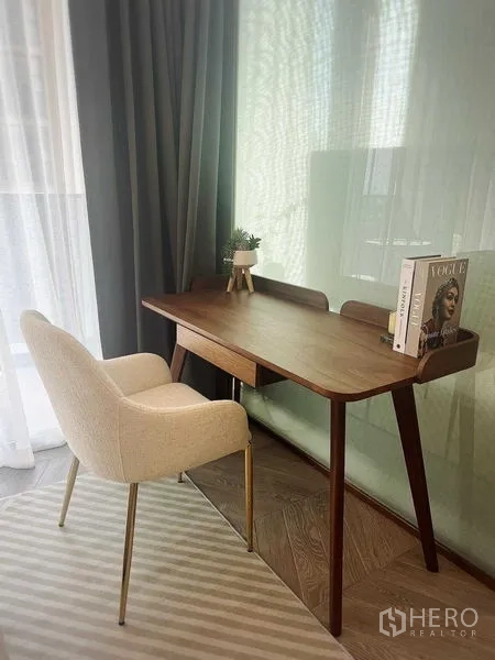 公寓 出租在Khlong Toei, Bangkok - 窗边木质书桌与软包椅的工作角落