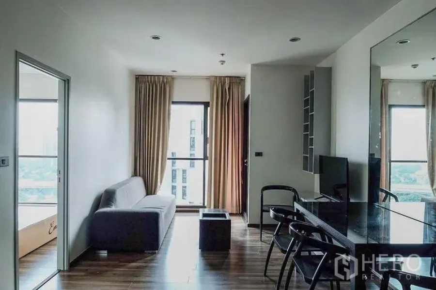 คอนโด ให้เช่าในKhlong Toei, Bangkok - พื้นที่นั่งเล่นและทานอาหารแบบเปิด โซฟา หน้าต่างสูง และชั้นวางทีวี