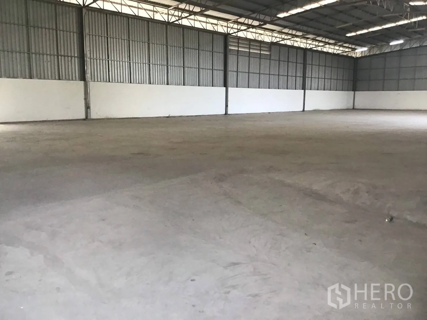 Warehouse for rent in Lat Krabang, Bangkok - Wide-span warehouse with white lower walls and even roof lighting.