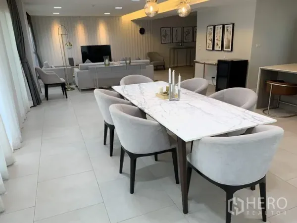 Condominium for rent in Sathon, Bangkok - Marble-top dining table with six upholstered chairs beside full-height windows.