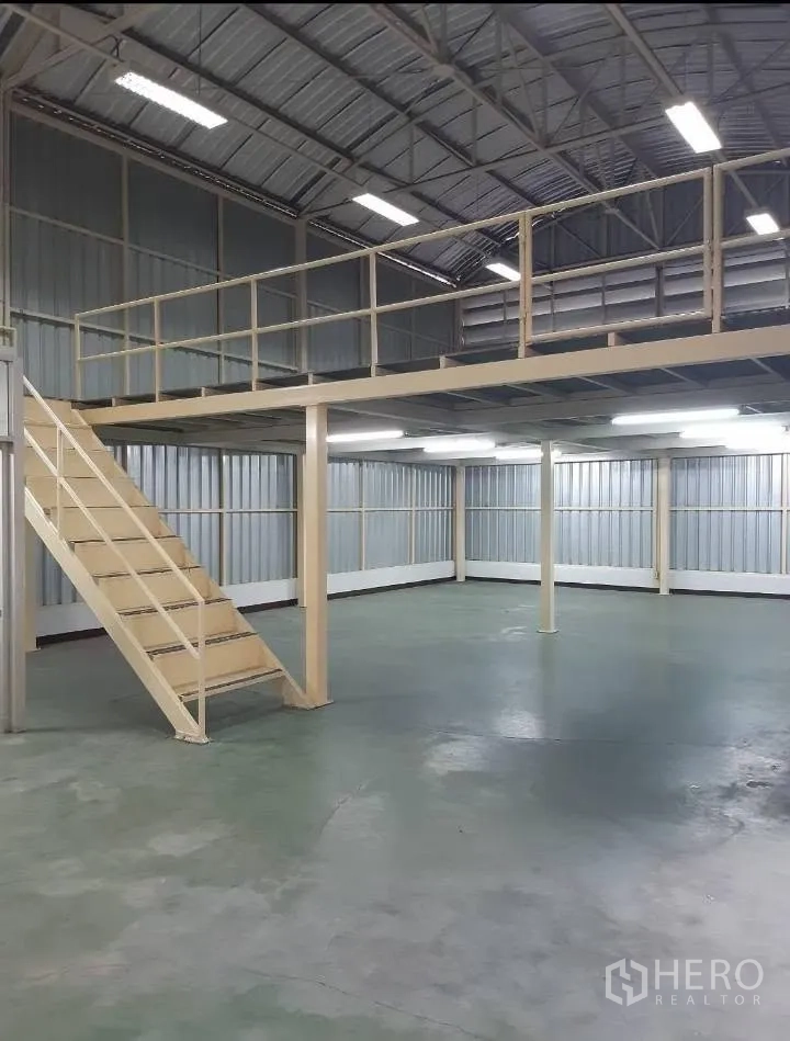 Warehouse for rent in Bang Kho Laem, Bangkok - Open ground floor space with mezzanine level and overhead lighting inside the warehouse.
