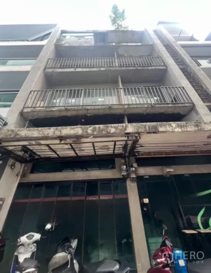 店屋 出售 - 四层店屋外立面，混凝土阳台与玻璃门面。