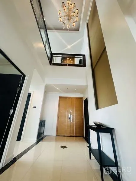 คอนโด ให้เช่าหรือขายในKhlong Toei, Bangkok - โถงทางเข้ากว้าง เพดานสูงสองชั้น โคมแชนเดอเลียร์ และประตูไม้คู่