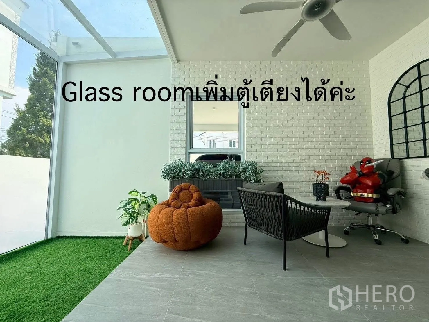 Detached House for rent in Bang Phli, Samut Prakan - Bright glass room with ceiling fan, seating, and faux grass edge.