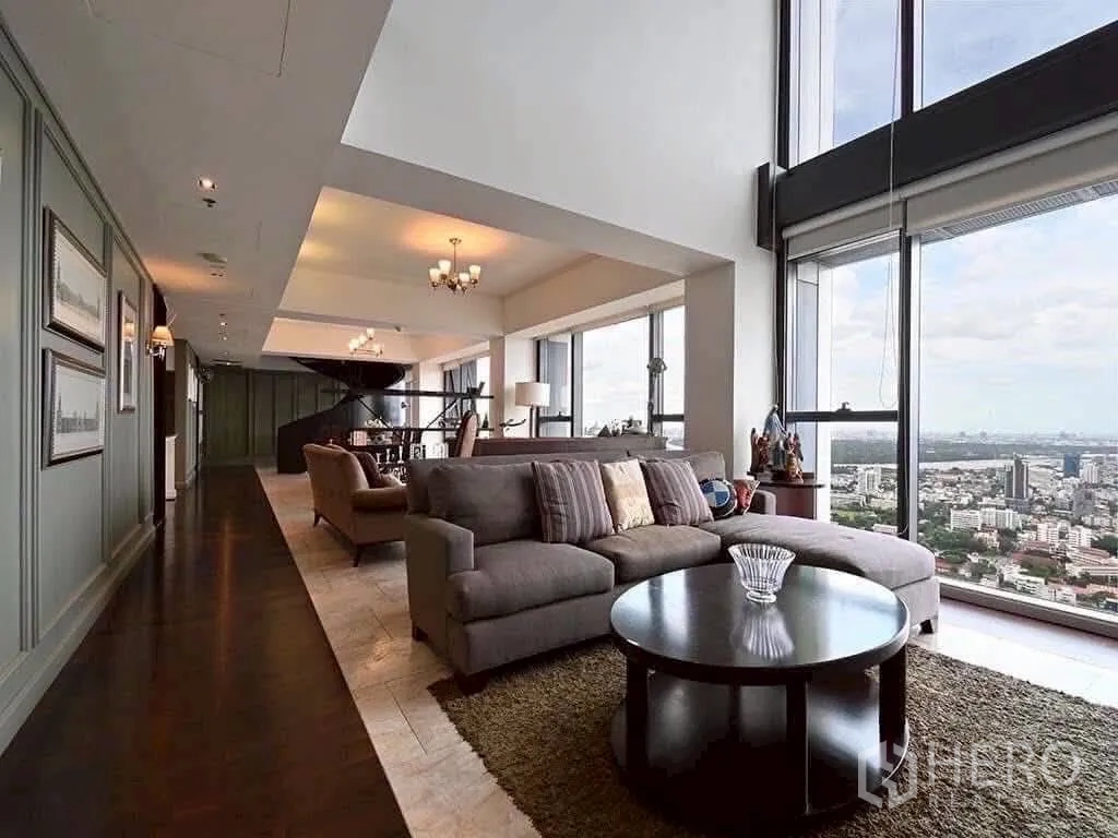 Condominium for rent in Sathon, Bangkok - Expansive open-plan lounge with panoramic river and city views through tall glazing and a comfortable sofa set.
