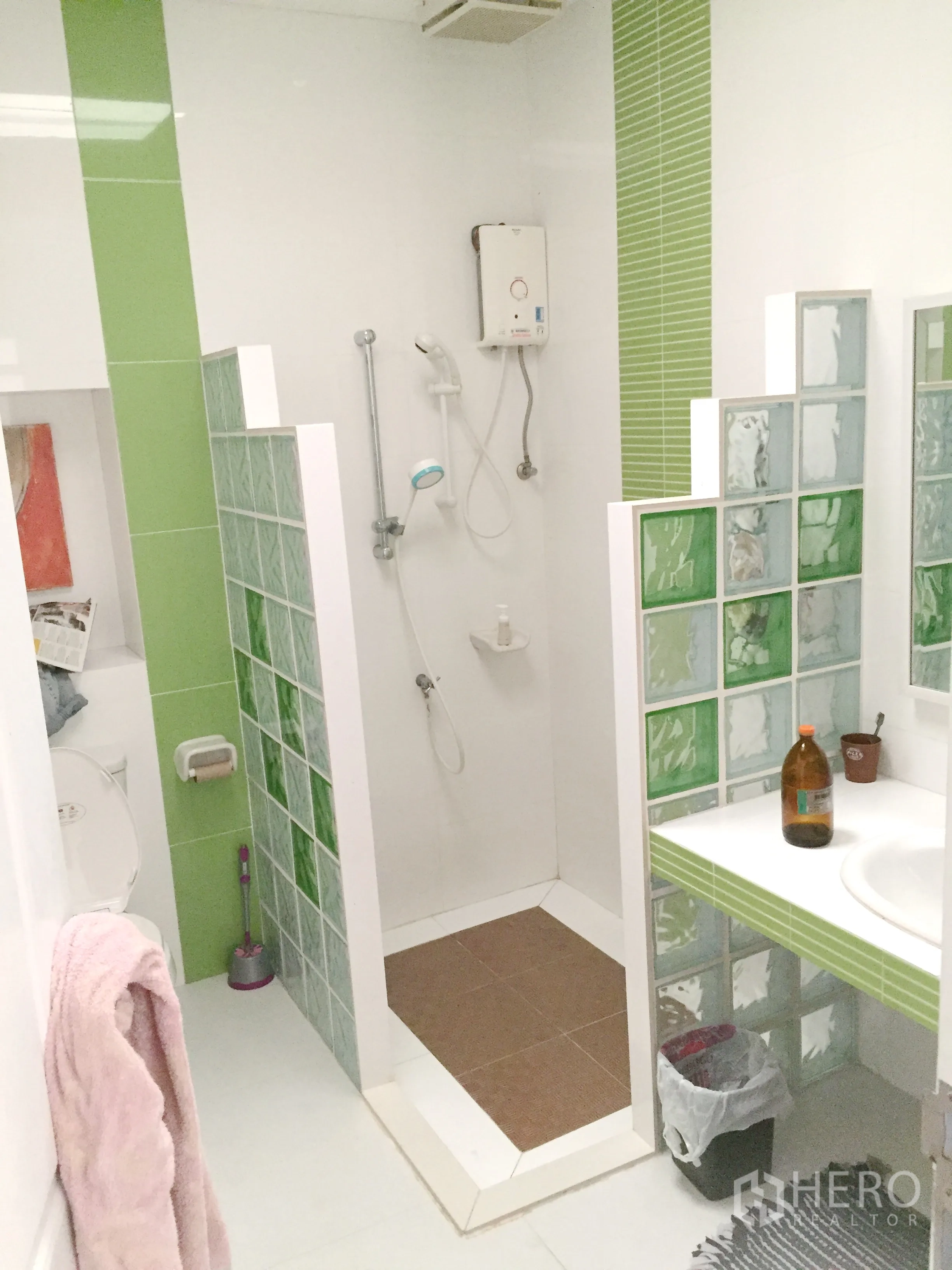 Townhouse for rent in Khlong Toei, Bangkok - Modern bathroom featuring green and white tiles, glass‑block partition and a walk‑in shower.