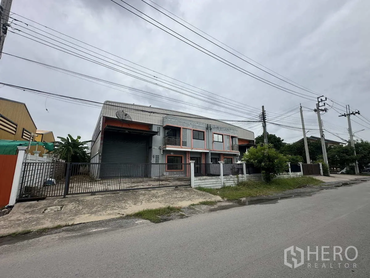 คลังสินค้า ให้เช่าหรือขายในBang Yai, Nonthaburi - ภาพด้านหน้าทางถนนของอาคารโกดัง รั้วและทางรถเข้า