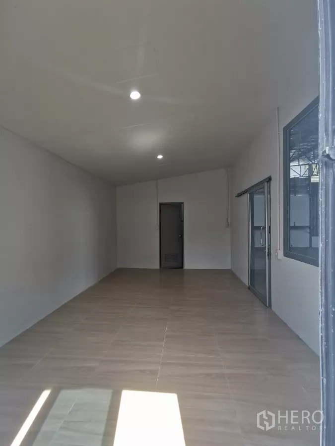 Warehouse for rent in Min Buri, Bangkok - Bright tiled office room with ceiling lights adjacent to the warehouse floor.