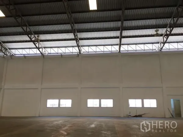 Factory for rent in Bang Bo, Samut Prakan - Spacious factory interior with tall walls, clerestory windows and concrete floor.