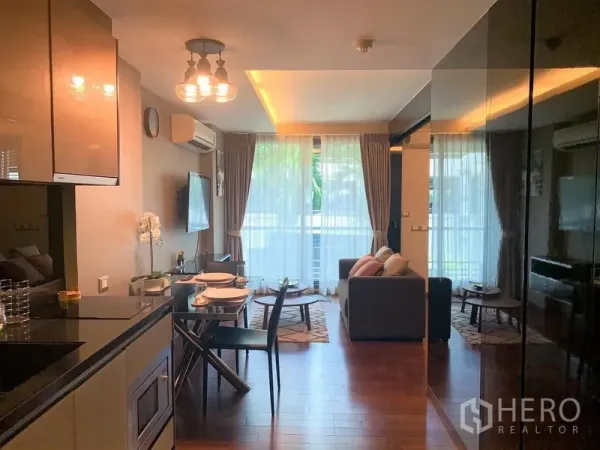 Condominium for rent in Watthana, Bangkok - Open-plan living room with floor-to-ceiling windows, dining set and compact kitchen in an Ekkamai condo.
