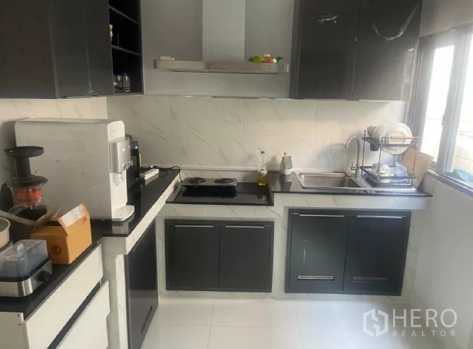 บ้าน ให้เช่าหรือขายในSaphan Sung, Bangkok - ครัวรูปตัวแอล ตู้สีดำ เตา ฮูดดูดควัน และหน้าต่าง