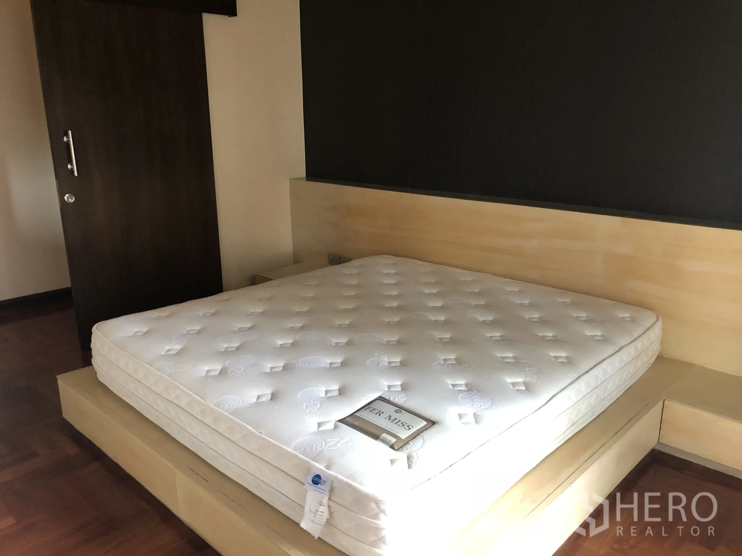 公寓 出租在Sathon, Bangkok - 卧室带平台床座、深色推拉门与木地板。