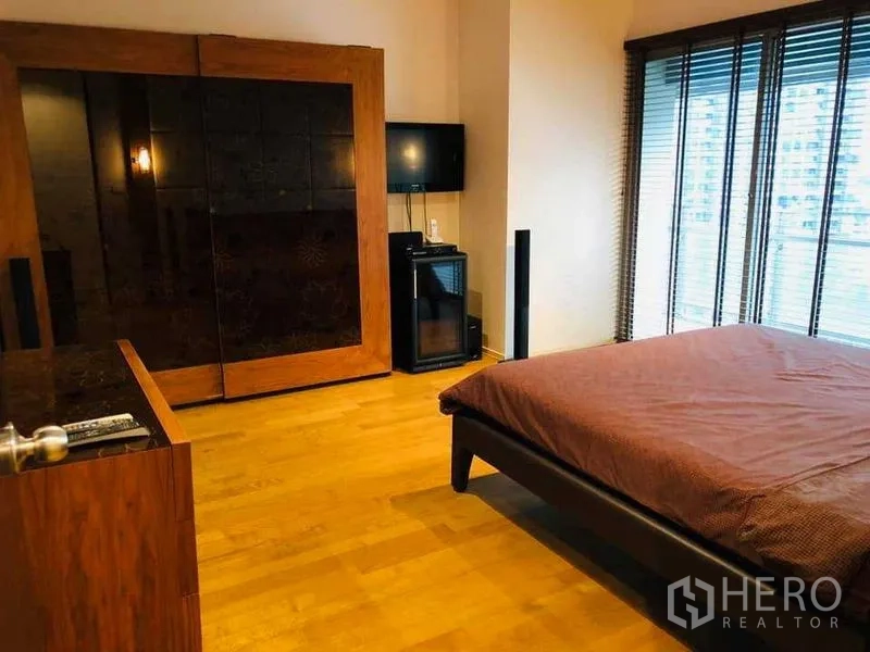 คอนโด ให้เช่าหรือขายในWatthana, Bangkok - ห้องนอนหลักพื้นไม้ ตู้เสื้อผ้าใบใหญ่ ทีวี และหน้าต่างมุมมองเมือง
