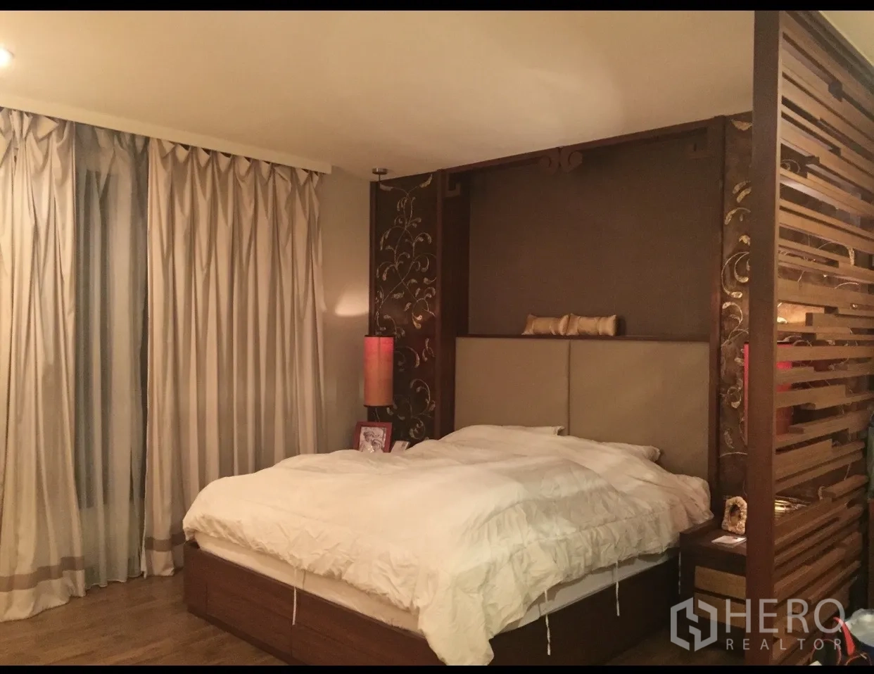 Condominium for sale in Yan Nawa, Bangkok - Master bedroom with upholstered headboard, wooden partition and full-length drapes.