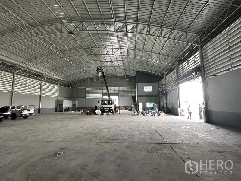 Factory for rent in Pathum Thani - Open-plan production hall with high clearance, louvered walls and wide loading doors.
