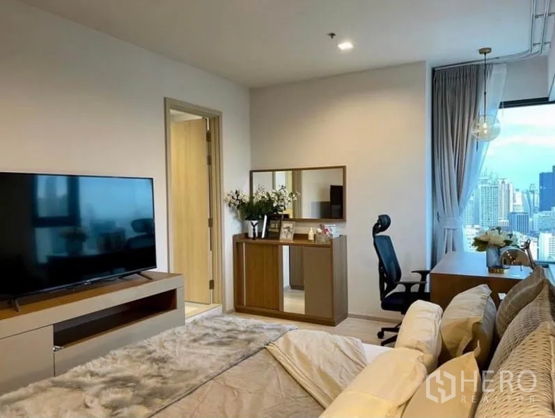 Condominium for rent in Pathum Wan, Bangkok - Master bedroom view with TV console, dresser, and door to the ensuite bathroom.