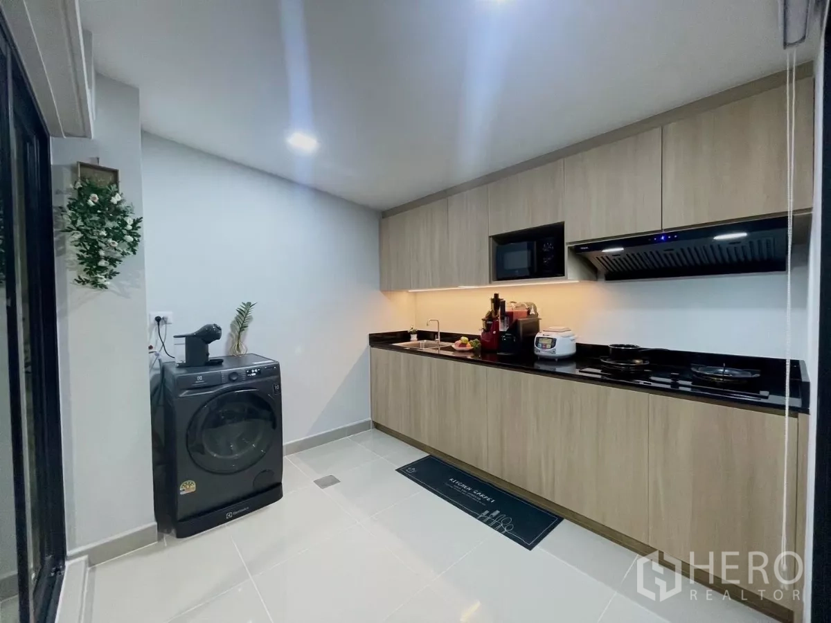 ทาวน์เฮาส์ ให้เช่าในSamut Prakan - มุมครัวพร้อมเครื่องซักผ้า Electrolux เครื่องใช้ไฟฟ้า และประตูกระจกบานเลื่อน