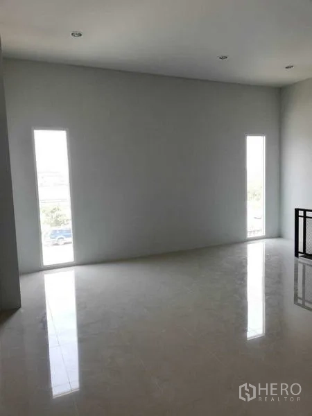 Warehouse for rent in Mueang Samut Sakhon, Samut Sakhon - Bright upstairs office room with glossy tile floor and two slim vertical windows.