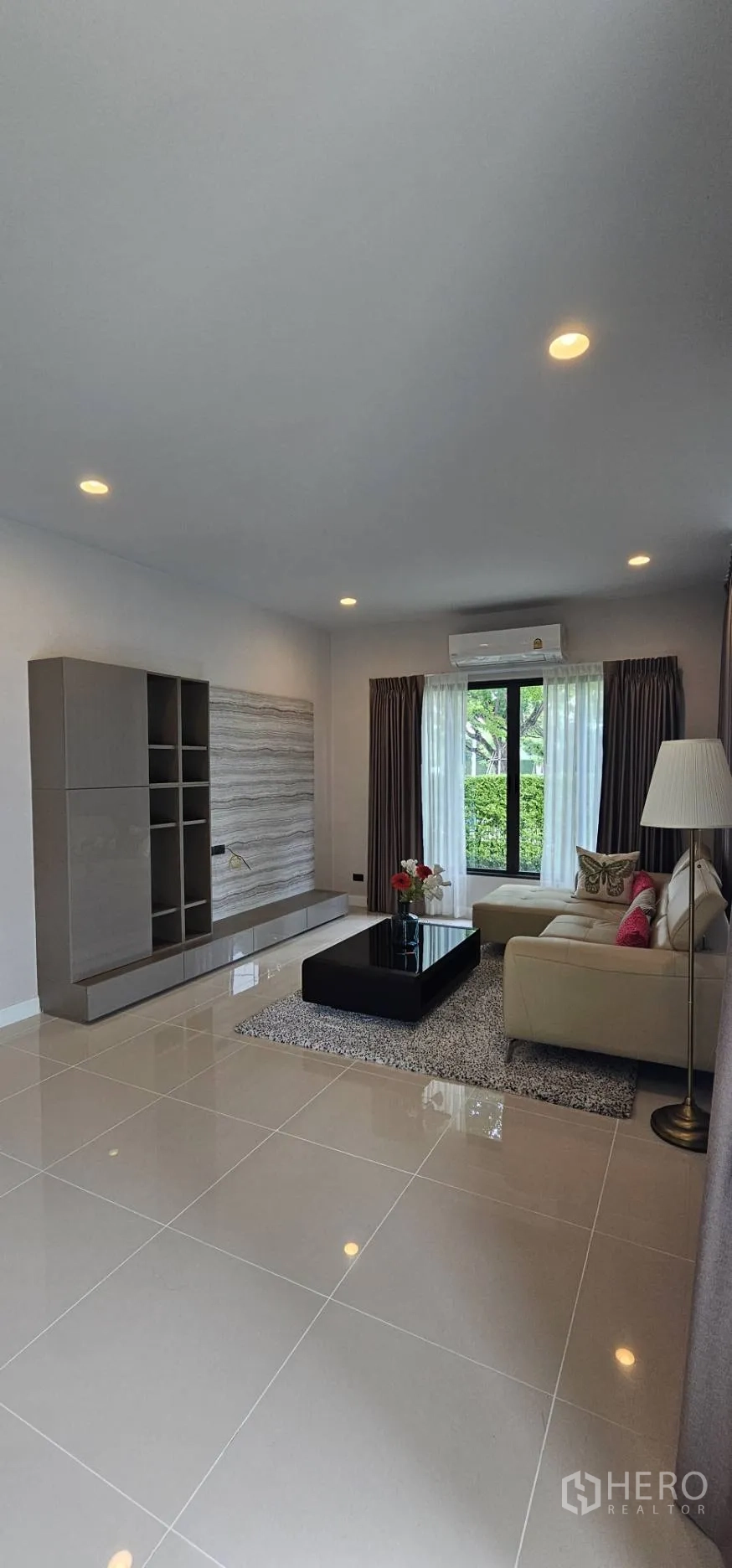Detached House for rent in Bang Kapi, Bangkok - Bright living room with built-in media wall, sofa and large window.