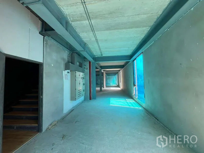 零售空间 出租在Pathum Wan, Bangkok - 服务走廊，裸露管线与控制箱，侧窗带来自然光。