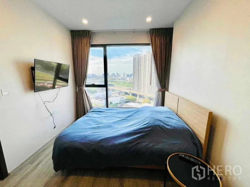 คอนโด ให้เช่าในHuai Khwang, Bangkok - ห้องนอนหลักติดทีวีผนัง พร้อมหน้าต่างบานใหญ่เห็นวิวเมือง