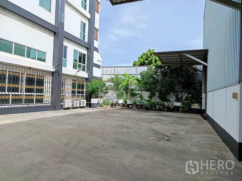 工厂 出售在Ban Phaeo, Samut Sakhon - 办公楼立面，大面积窗户、室外空调机与绿植花盆