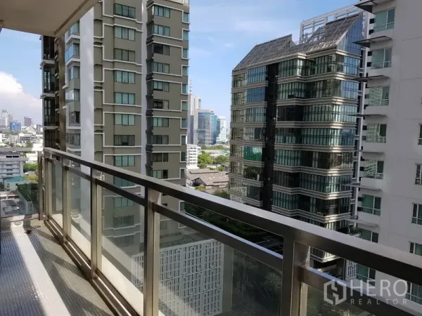 公寓 出租在Khlong Toei, Bangkok - 带玻璃栏杆的私家阳台，俯瞰曼谷高楼天际线。