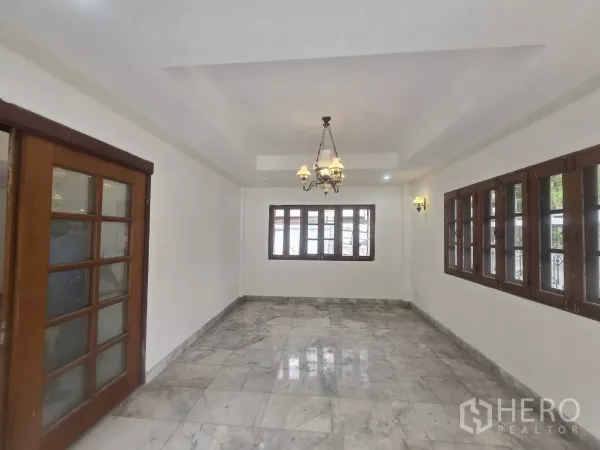 独立式住宅 出租在Phra Khanong, Bangkok - 采光客厅，大理石地面、吊灯与木框窗