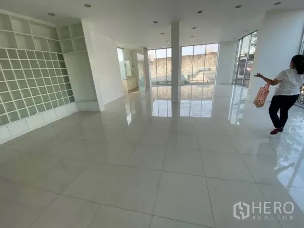 零售空间 出租在Bueng Kum, Bangkok - 开放式展厅，白色瓷砖地面、置物墙与落地窗。