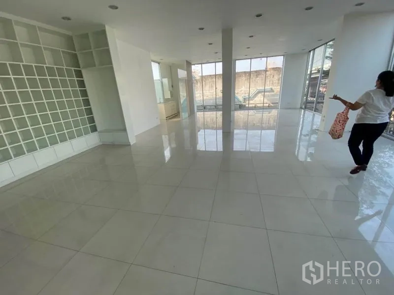 零售空间 出租在Bueng Kum, Bangkok - 开放式展厅，白色瓷砖地面、置物墙与落地窗。