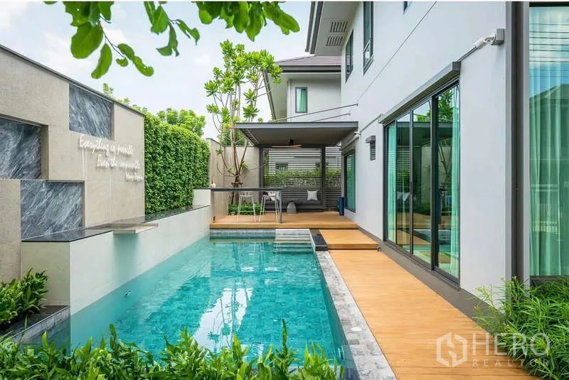 Detached House for rent or sale in Bang Kapi, Bangkok - Daytime private lap pool with water feature, wood deck and covered terrace.