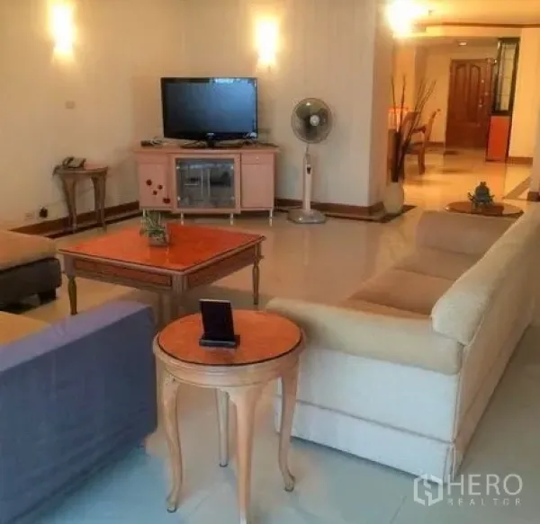 公寓 出租在Watthana, Bangkok - 宽敞客厅，配沙发组、电视柜和茶几，暖色照明的อโศก公寓。