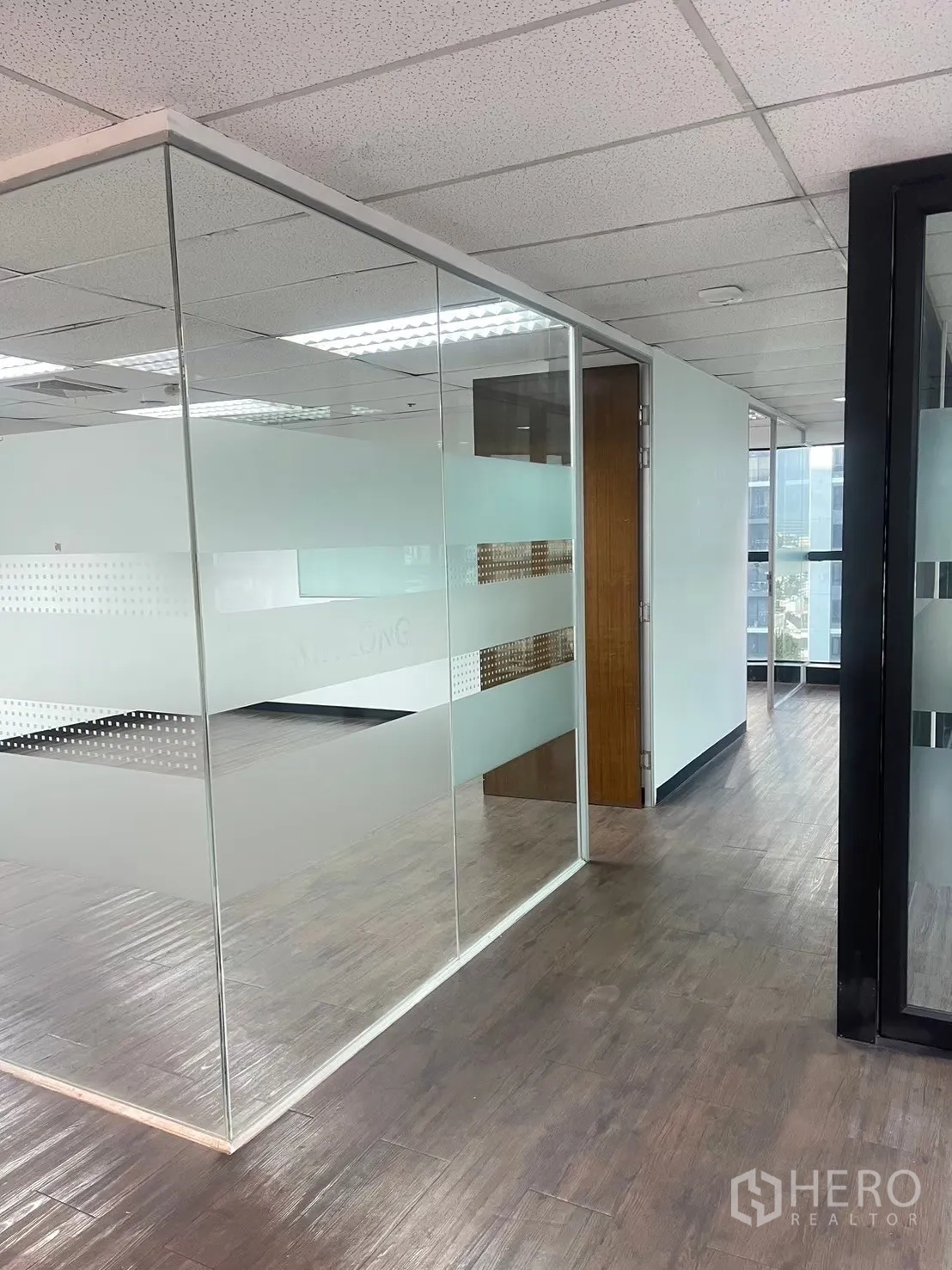 办公室 for rent in Watthana, Bangkok - 带磨砂条纹的玻璃隔断会议室与木纹地板。