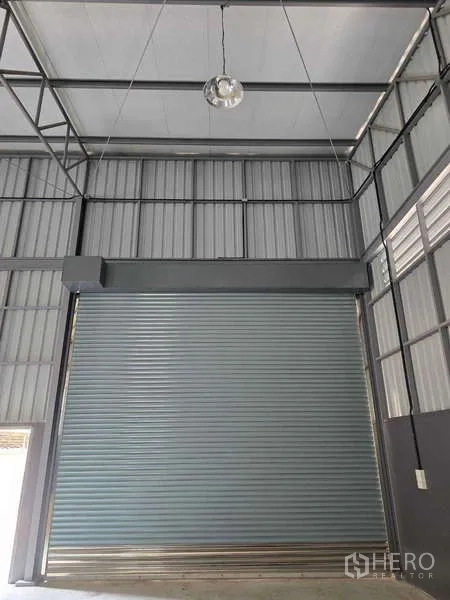 คลังสินค้า ให้เช่าในMueang Samut Sakhon, Samut Sakhon - ภาพใกล้ประตูม้วนสูงใต้เพดานโกดังและโครงเหล็ก