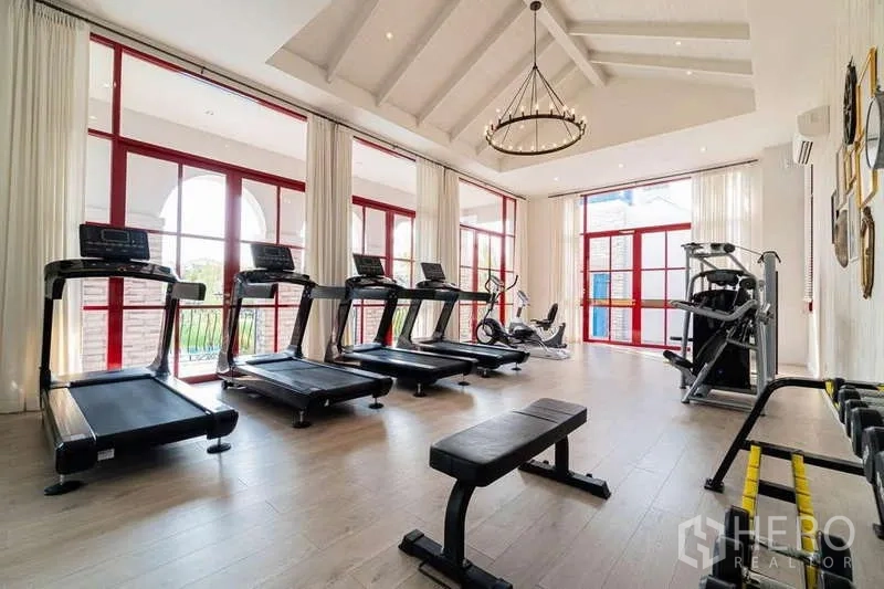 Detached House for rent in Prawet, Bangkok - Fitness center featuring treadmills, weight machines and high ceilings by large windows.
