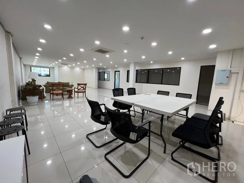 สำนักงานที่บ้าน ให้เช่าในBang Na, Bangkok - พื้นที่ทำงานโล่งมีโต๊ะประชุม หน้าต่างกรอบดำ และไฟเพดานสว่าง