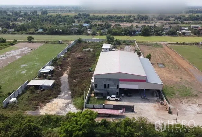 货栈 出售在Lam Luk Ka, Pathum Thani - 无人机视角：大宗土地，围墙、空旷堆场与仓库主体