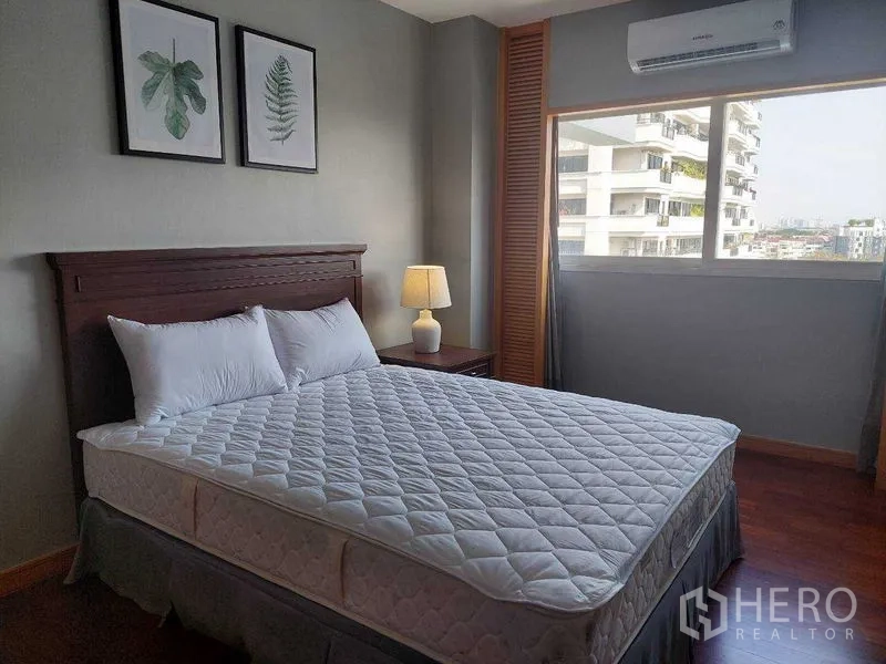 房间 出租 - 卧室带城市景观窗，双人床、床头灯、空调与木地板。