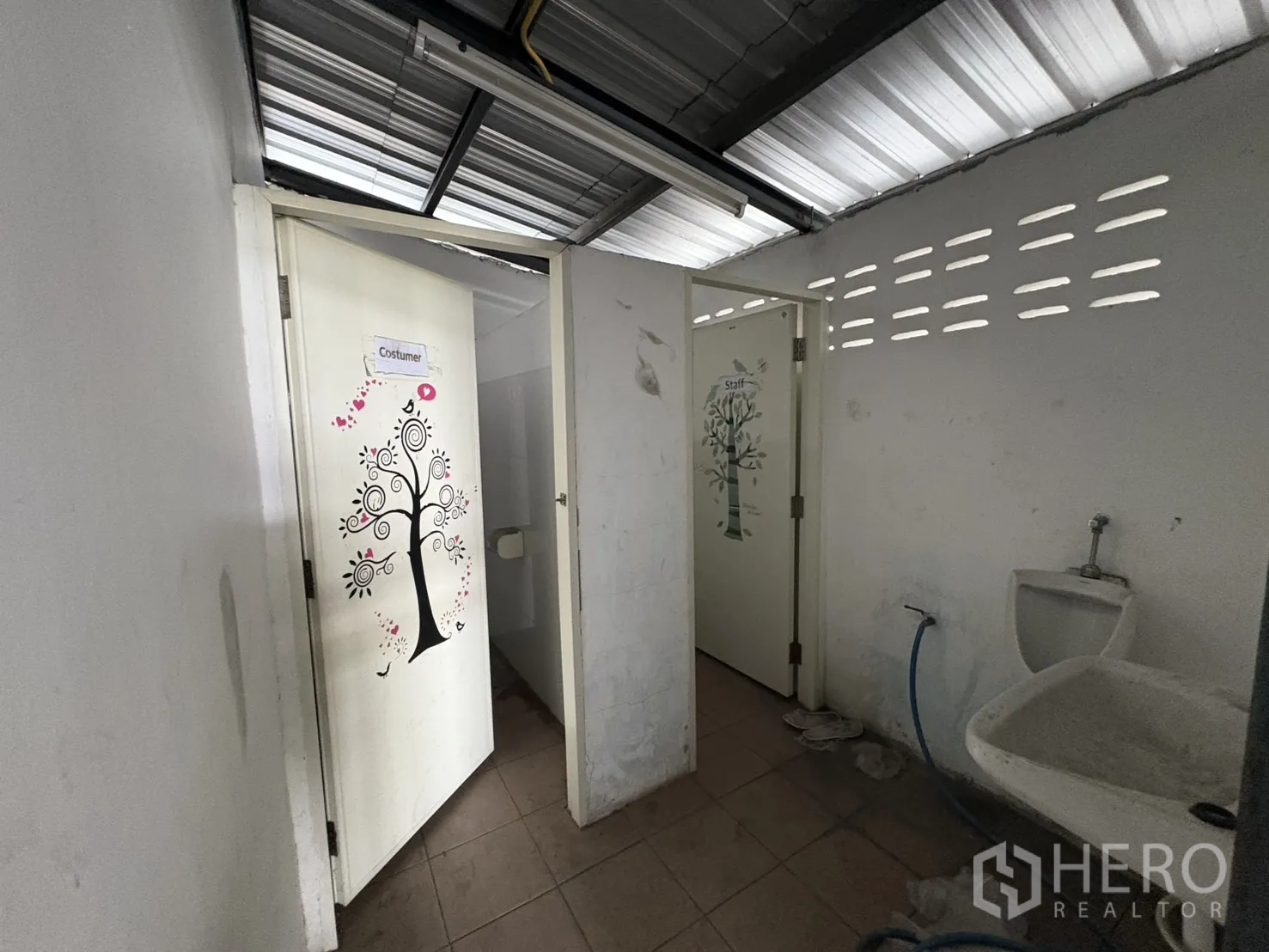 คลังสินค้า ให้เช่าในMueang Samut Prakan, Samut Prakan - อาคารห้องน้ำภายนอก มีห้องแยกหลายห้องและอ่างล้างมือ ใต้หลังคาระบายอากาศ.