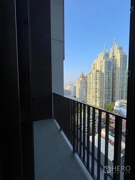 Condominium for rent - Private balcony with railing and panoramic skyline view of nearby high-rises.