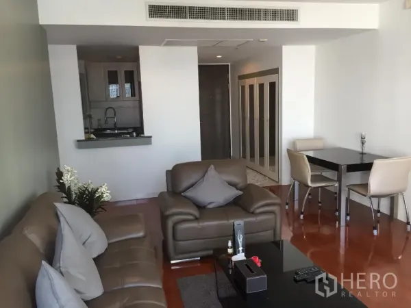 公寓 出租或出售在Khlong Toei, Bangkok - 开放式客厅，皮沙发、餐桌与吧台，抛光木地板。