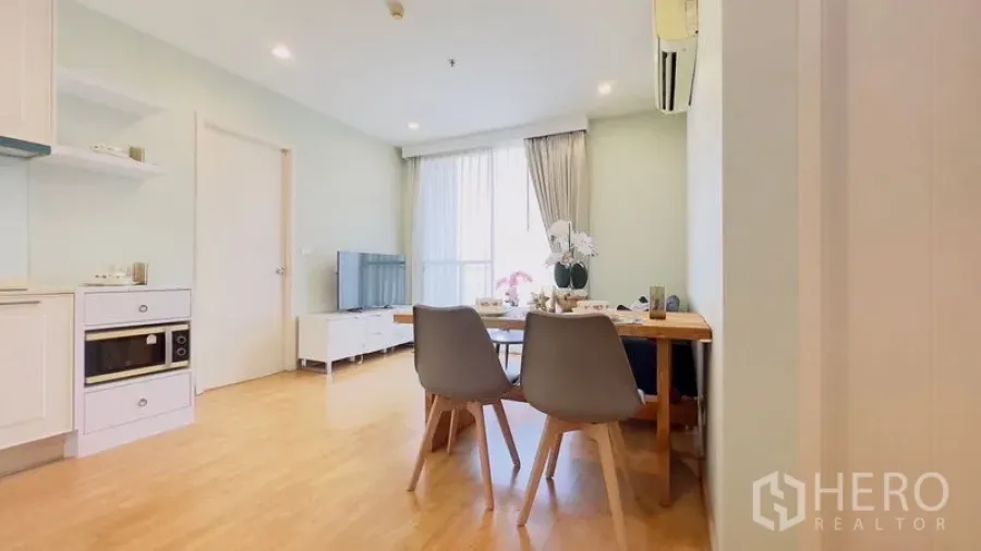 คอนโด ให้เช่าในWatthana, Bangkok - ห้องนั่งเล่นและรับประทานอาหารแบบเปิดโล่ง พื้นไม้ ครัวสีขาว ทีวี และหน้าต่างบานใหญ่