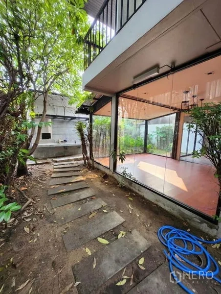 带办公室的家 出租在Lat Phrao, Bangkok - 玻璃房旁的花园小径，铺设踏步石，绿植环绕侧院。