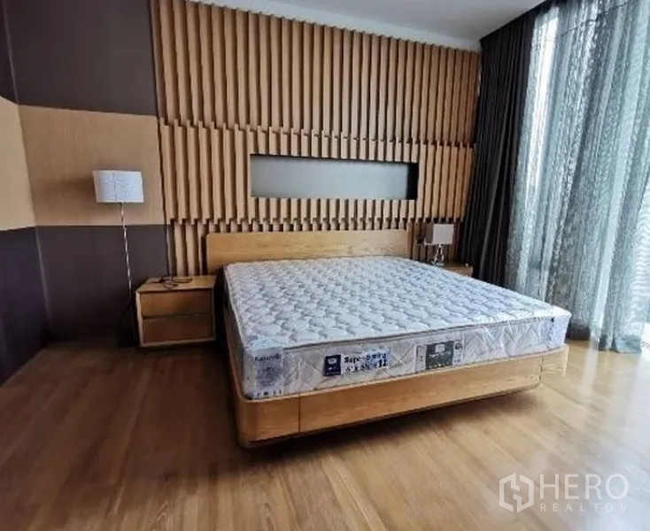 公寓 出租在Bang Rak, Bangkok - 主卧配木条纹景墙、平台床与全高窗帘。