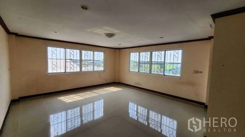 Factory for rent in Pak Kret, Nonthaburi - Bright corner office room with multiple windows and glossy tile floor
