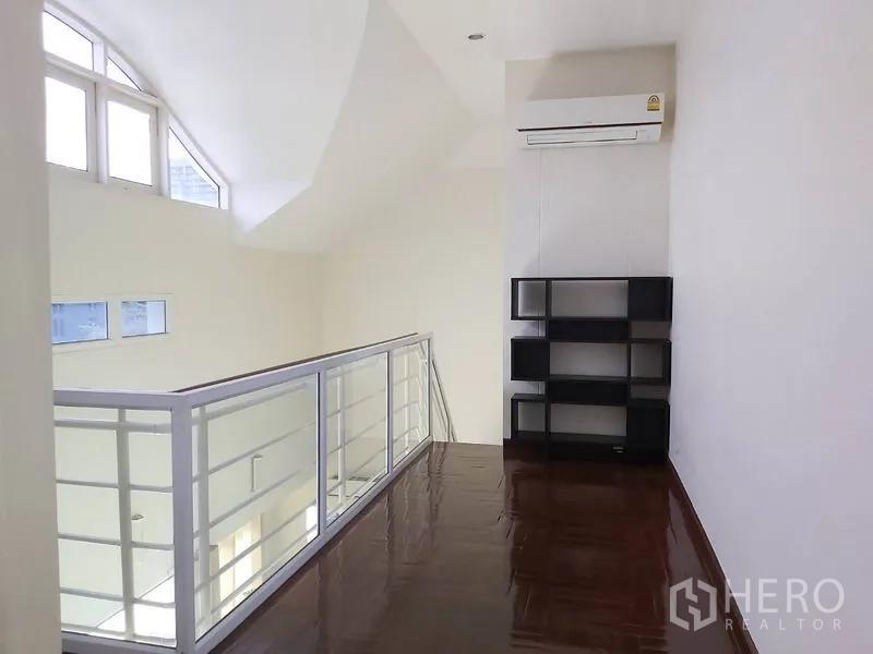 公寓 出租在Watthana, Bangkok - 夹层走道，白色栏杆、木地板、窗户及壁挂空调。