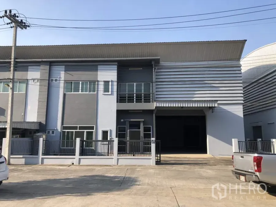 工厂 出租在Lam Luk Ka, Pathum Thani - 兰鲁甲区保安园区内的现代厂房外观，带两层办公区和大型卷闸门。